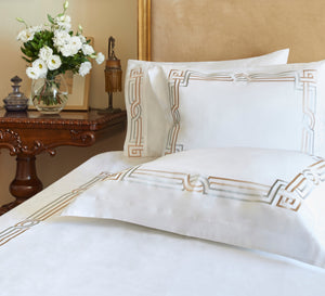 Deco Duvet Cover Set in white Egyptian cotton with Art Deco-inspired geometric embroidery – flanged shams and pillowcases on bed, styled in luxury bedroom.