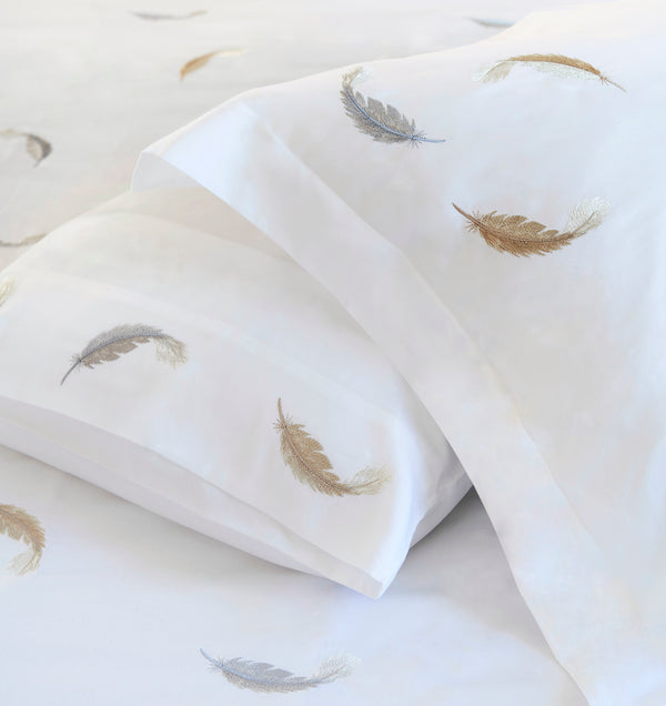 Detail of Feathers Duvet Cover Set – feather embroidered on white Egyptian cotton pillow shams and top sheet.
