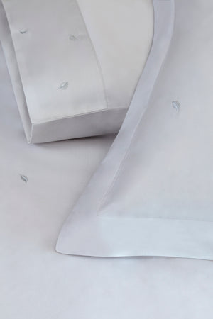 Detail of Mini Leaves Duvet Cover Set – small leaves embroidered on Egyptian cotton pillow shams and top sheet.