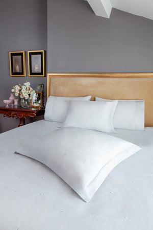 Mini Leaves Duvet Cover Set in white Egyptian cotton with small leaf embroidery – flanged shams and pillowcases on bed, styled in luxury bedroom.