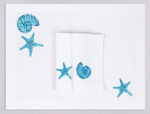 White linen placemat and napkin set embroidered with turquoise starfish and nautilus, 100% European linen, handcrafted by Plein Soleil.
