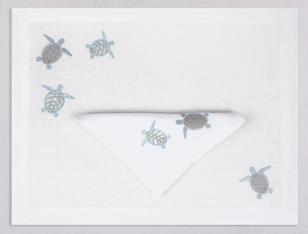 White linen placemat and napkin set embroidered with ice blue sea turtles, 100% European linen, handcrafted by Plein Soleil.