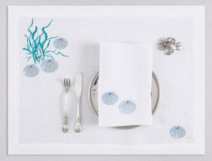 White linen placemat and napkin set embroidered with ice blue sea urchin and seaweed, 100% European linen, handcrafted by Plein Soleil.