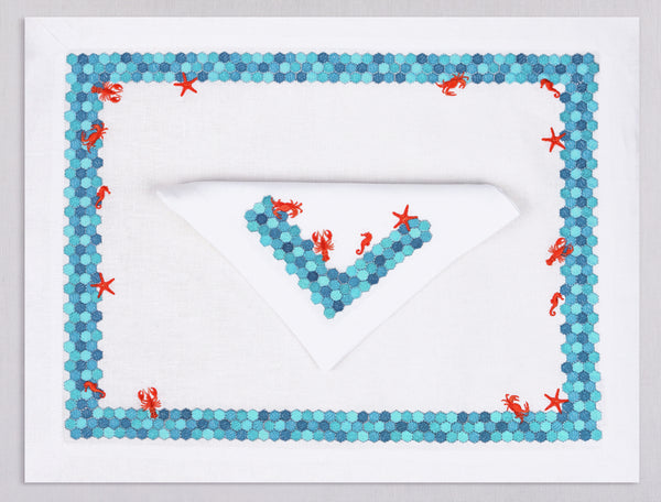 White linen placemat and napkin set embroidered with turquoise border and red sea animals, 100% European linen, handcrafted by Plein Soleil.