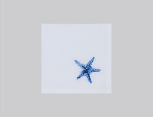 White linen cocktail napkin embroidered with blue starfish, 100% European linen, handcrafted by Plein Soleil.
