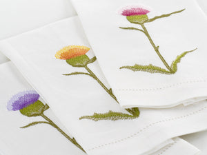 Set of white linen guest towels embroidered with purple, yellow, and pink thistle flowers – luxury floral bath linens by Plein Soleil.
