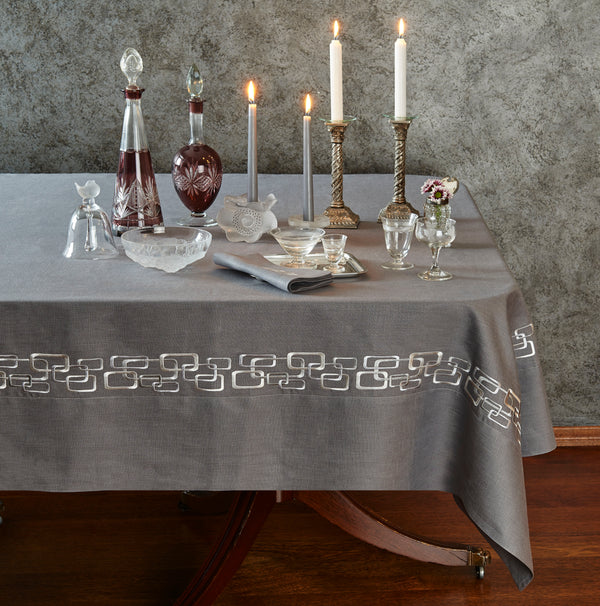 A table set with lit candles and an elegant tablecloth, creating a warm and inviting atmosphere.