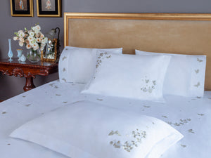 Butterfly Blossom Duvet Cover Set in white Egyptian cotton with butterfly embroidery – flanged shams and pillowcases on bed, styled in luxury bedroom.