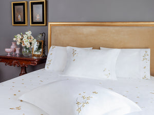 Cherry Blossom Duvet Cover Set in white Egyptian cotton with flower embroidery – flanged shams and pillowcases on bed, styled in luxury bedroom.