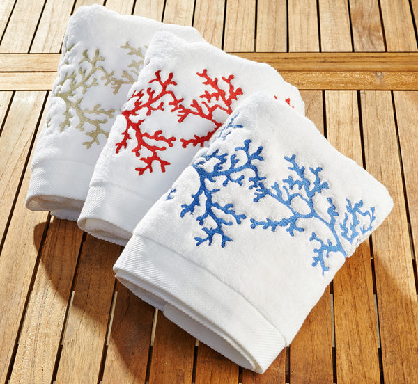 Set of white terry guest towels embroidered with coral motifs in red, blue, and beige – soft, absorbent, and coastal-inspired bath linens by Plein Soleil.