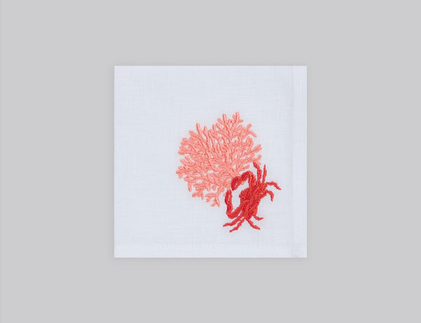White cocktail napkin set embroidered with a salmon colored coral and red crab, 100% European linen, handcrafted by Plein Soleil.