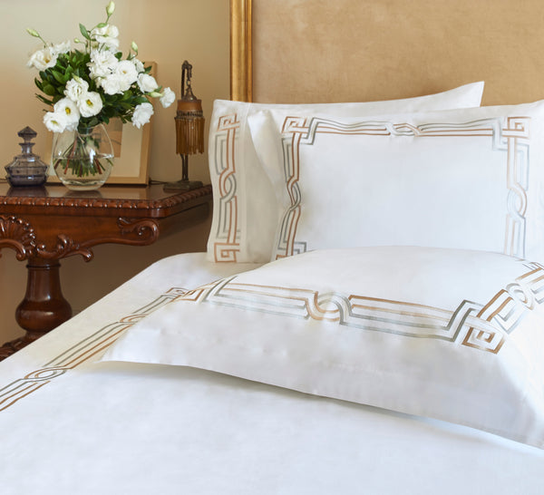 Deco Duvet Cover Set in white Egyptian cotton with Art Deco-inspired geometric embroidery – flanged shams and pillowcases on bed, styled in luxury bedroom.