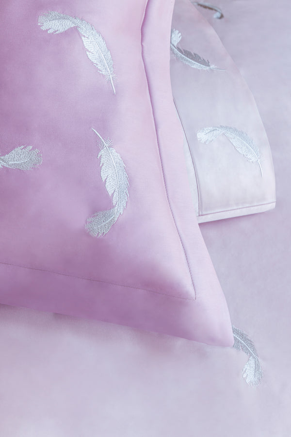 Detail of Feathers Duvet Cover Set – feather embroidered on light rose Egyptian cotton pillow shams and top sheet.