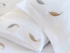 Detail of Feathers Duvet Cover Set – feather embroidered on white Egyptian cotton pillow shams and top sheet.