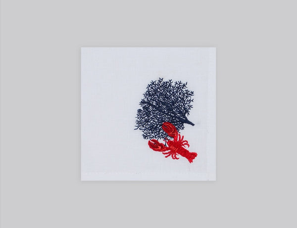 White cocktail napkin set embroidered with a navy coral and red lobster, 100% European linen, handcrafted by Plein Soleil.