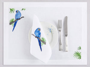 White linen placemat and napkin set embroidered with blue macau bird, 100% European linen, handcrafted by Plein Soleil.