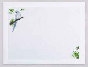 White linen placemat and napkin set embroidered with ice blue macau bird, 100% European linen, handcrafted by Plein Soleil.