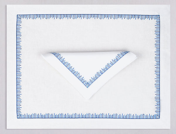 White linen placemat and napkin set embroidered with blue mikado motif border, 100% European linen, handcrafted by Plein Soleil.