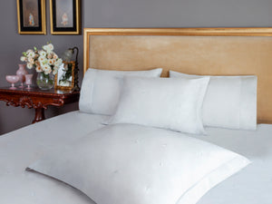 Mini Leaves Duvet Cover Set in white Egyptian cotton with small leaf embroidery – flanged shams and pillowcases on bed, styled in luxury bedroom.