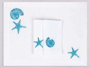 White linen placemat and napkin set embroidered with turquoise starfish and nautilus, 100% European linen, handcrafted by Plein Soleil.