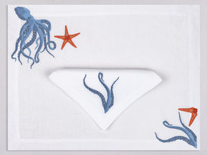 White linen placemat and napkin set embroidered with a blue octopus and orange starfish, 100% European linen, handcrafted by Plein Soleil.