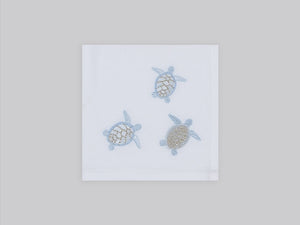 White linen cocktail napkin embroidered with ice blue sea turtles, 100% European linen, handcrafted by Plein Soleil.