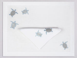 White linen placemat and napkin set embroidered with ice blue sea turtles, 100% European linen, handcrafted by Plein Soleil.