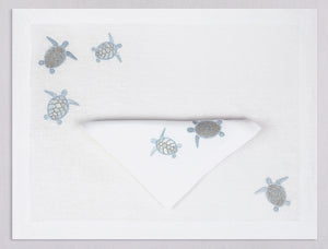 White linen placemat and napkin set embroidered with ice blue sea turtles, 100% European linen, handcrafted by Plein Soleil.