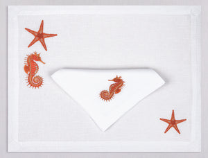 White linen placemat and napkin set embroidered with orange seahorse and starfish, 100% European linen, handcrafted by Plein Soleil.