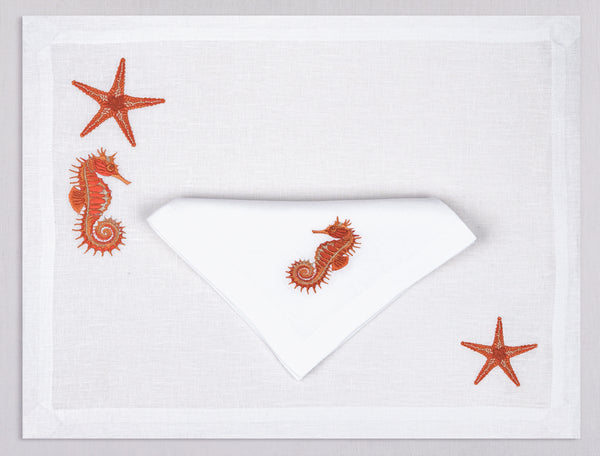 White linen placemat and napkin set embroidered with orange seahorse and starfish, 100% European linen, handcrafted by Plein Soleil.