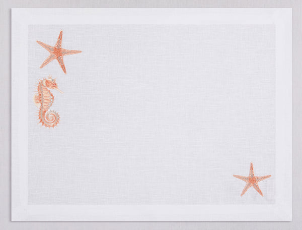 White linen placemat and napkin set embroidered with salmon colored seahorse and starfish, 100% European linen, handcrafted by Plein Soleil.