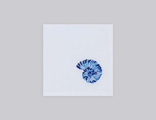 White linen cocktail napkin embroidered with blue shell, 100% European linen, handcrafted by Plein Soleil.