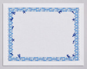 White linen placemat and napkin set embroidered with blue border and red sea animals, 100% European linen, handcrafted by Plein Soleil.