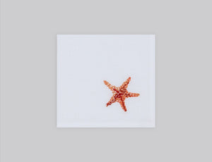 White linen cocktail napkin embroidered with orange starfish, 100% European linen, handcrafted by Plein Soleil.