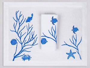 White linen placemat and napkin set embroidered with blue fish and corals, 100% European linen, handcrafted by Plein Soleil.
