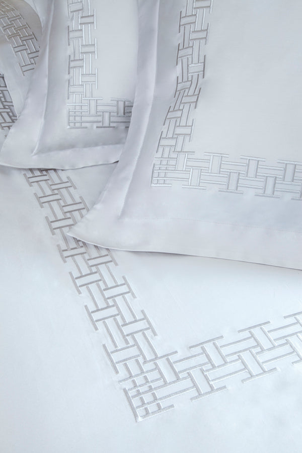 Detail of Versa Duvet Cover Set – geometric embroidered border on Egyptian cotton pillow shams and top sheet.