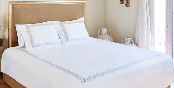 Neatly made bed in a well-lit bedroom with decorative elements.