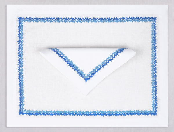 White linen placemat and napkin set embroidered with blue zig zag motif border, 100% European linen, handcrafted by Plein Soleil.